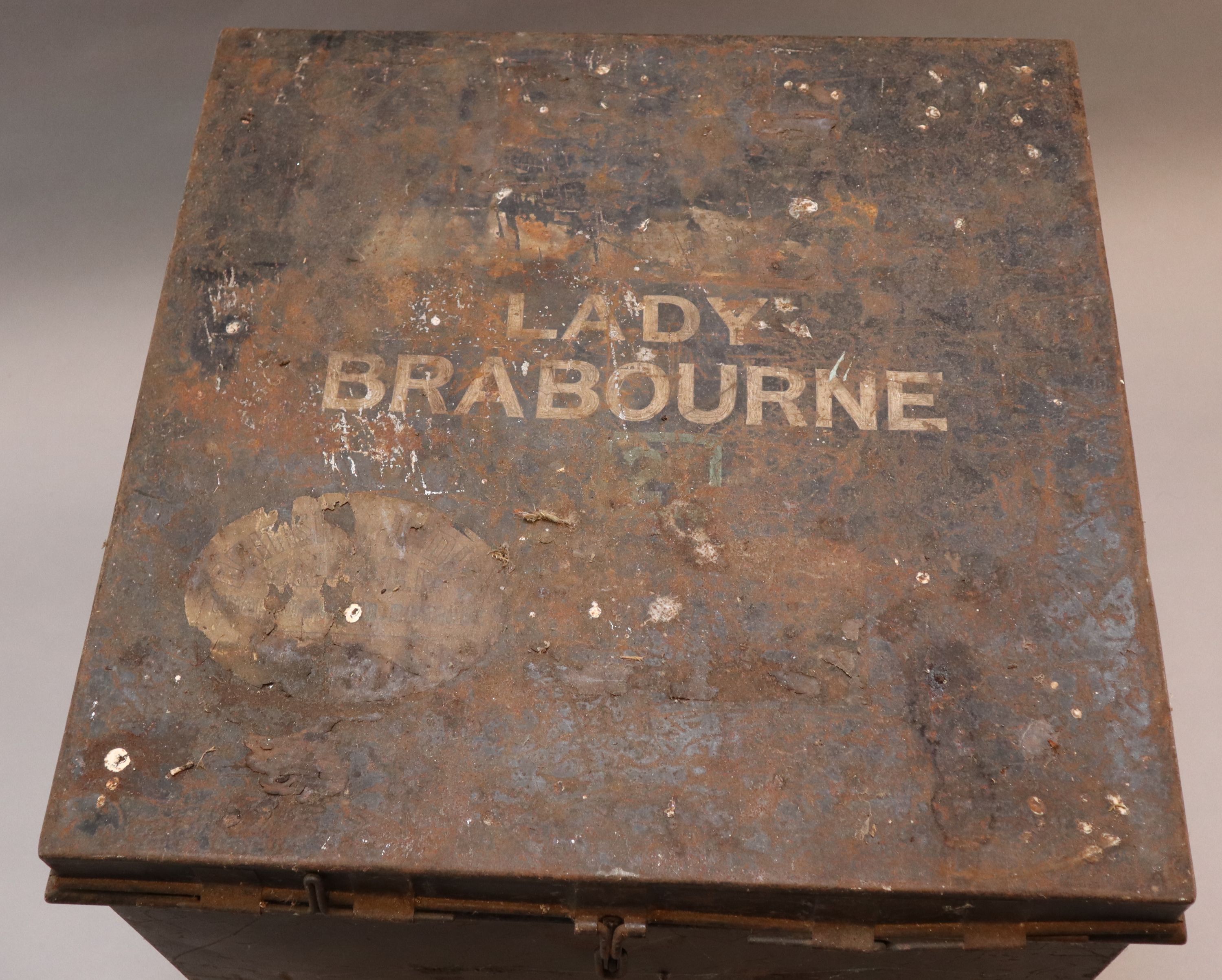 An early 20th century black painted tin travelling trunk, inscribed Lady Brabourne with old British India and Cooks Travel labels, wi